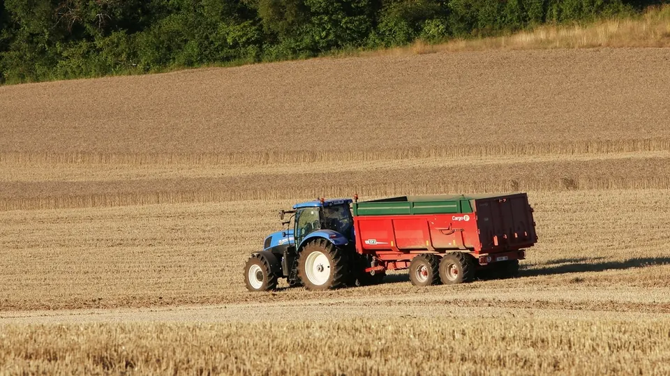 Tractor cu remorcă lucrând pe un teren agricol
